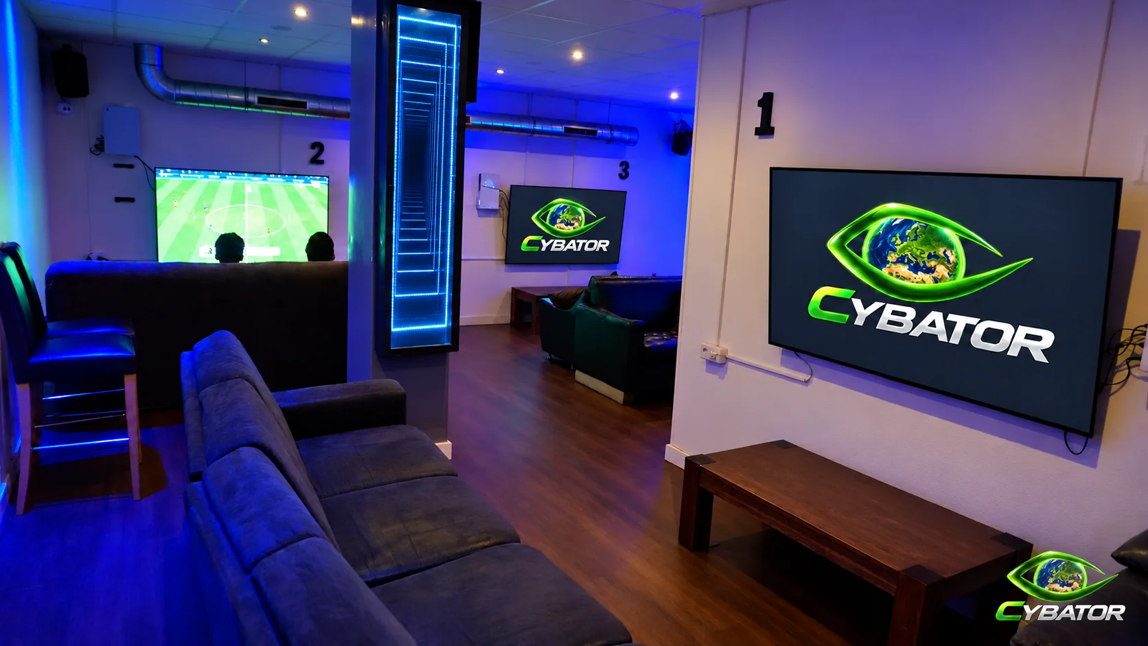 Konsolenbereich mit Sofas und großen Bildschirmen – Cybator